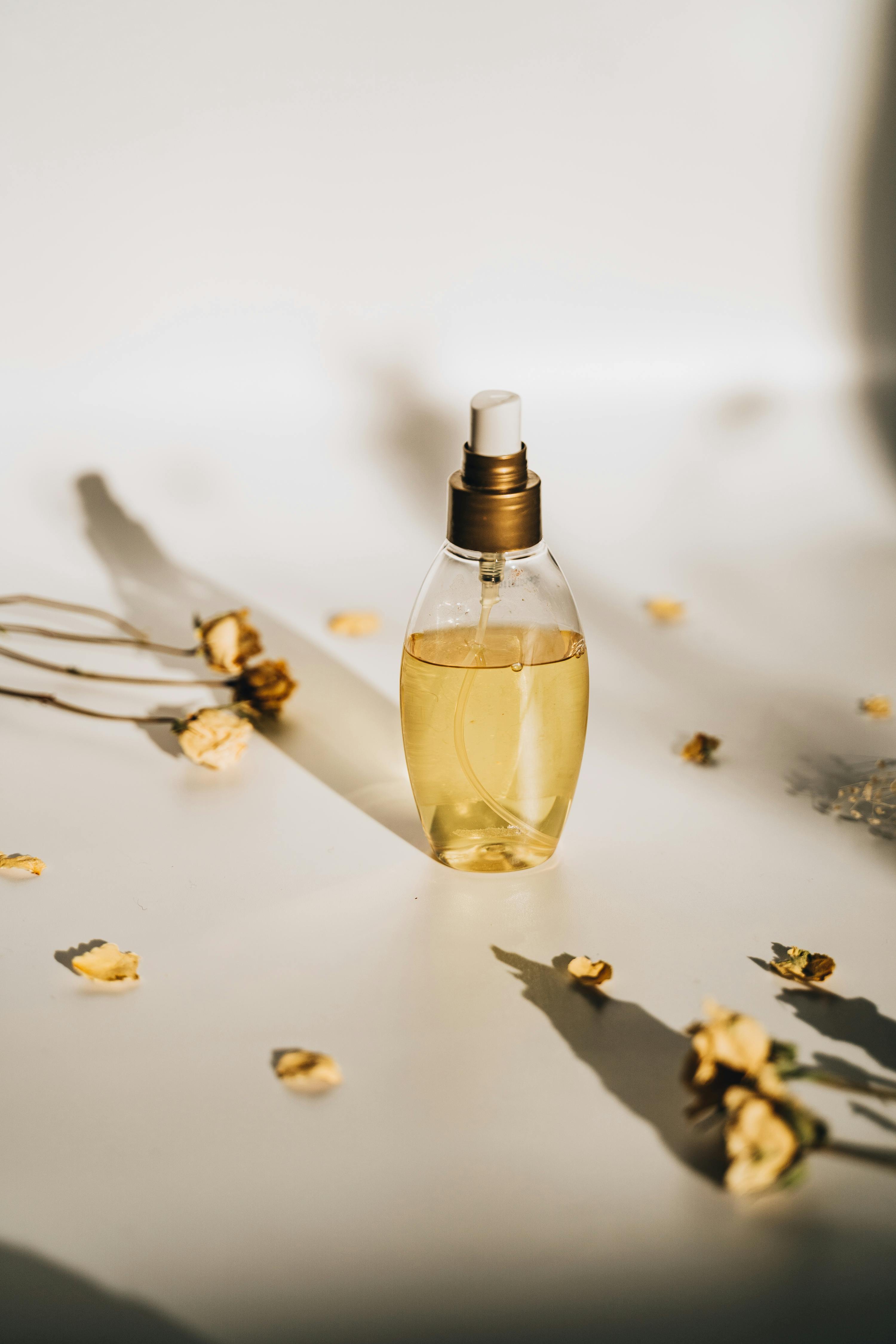 A stylish perfume bottle surrounded by dried flowers in a minimalist setting, perfect for product photography.