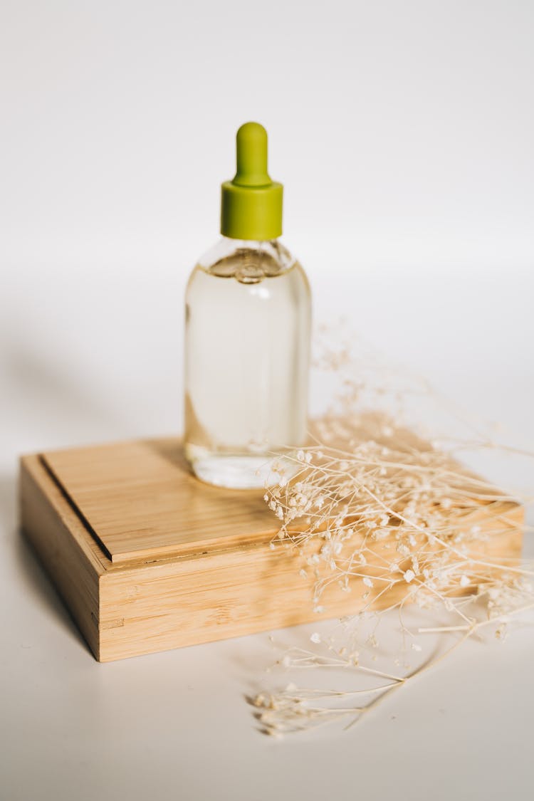 Clear Serum Bottle On Top Of A Wooden Box