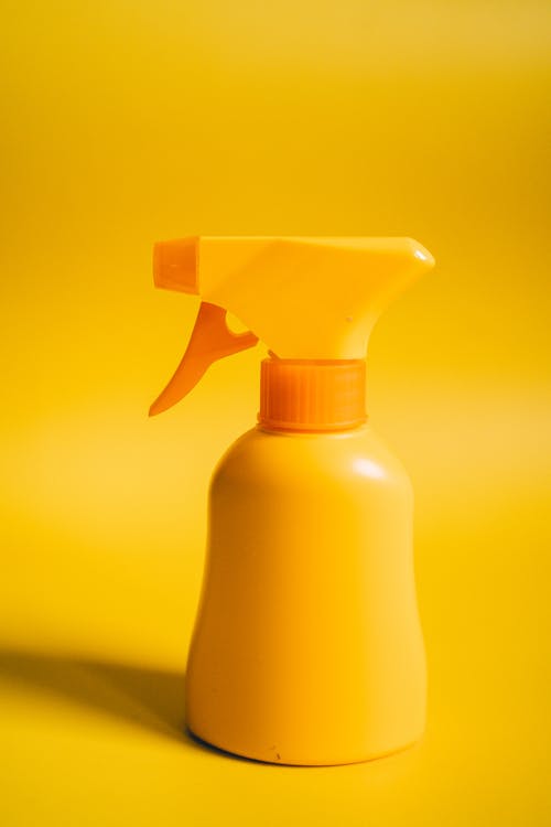Yellow Plastic Spray Bottle on Yellow Surface