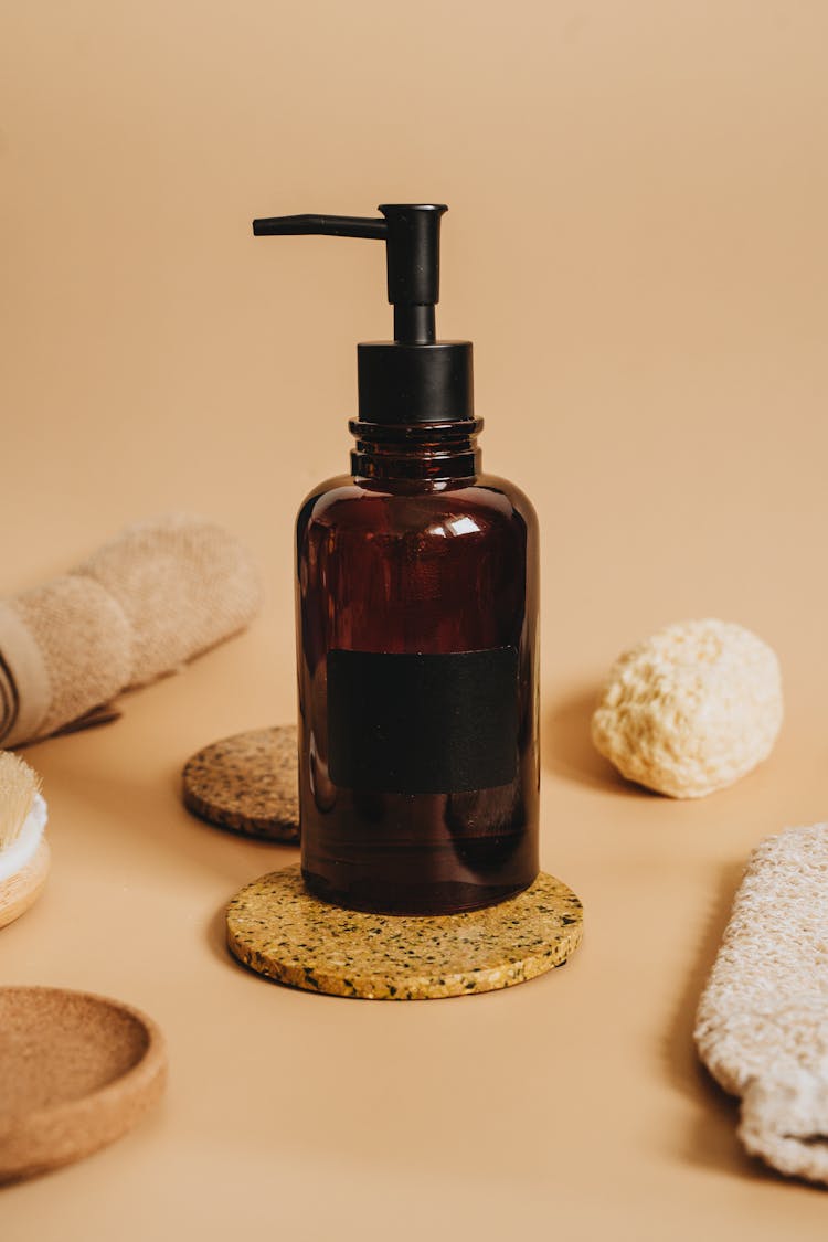 Brown Glass Bottle Pump On A Cork Coaster