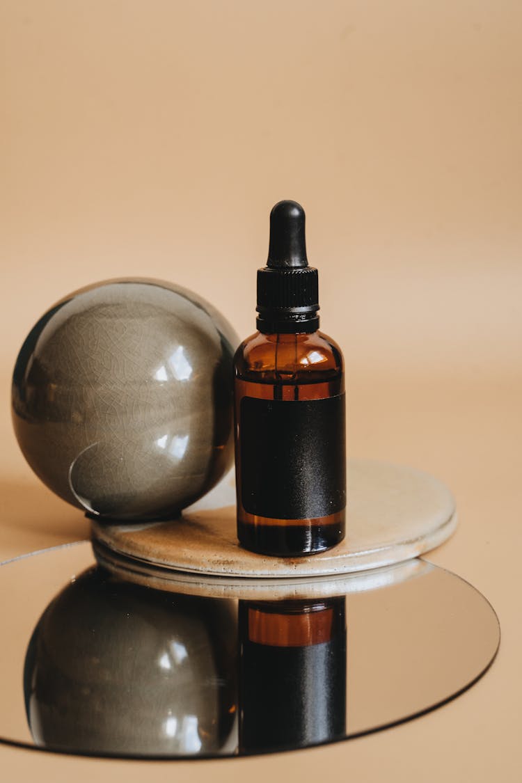 Brown Glass Bottle On Round Mirror