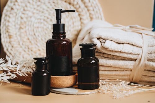 Free Elegant display of toiletry products featuring pump bottles, towels, and natural accents. Stock Photo