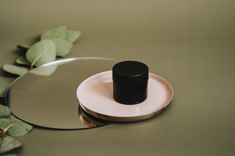 A Black Container On A Round Tray