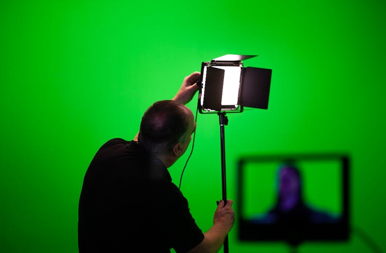 Man Fixing A Studio Lighting