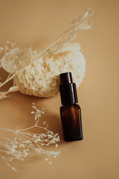 Elegant display of brown glass skincare bottle against natural textures and muted tones.