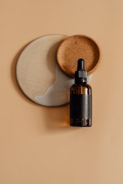 Dark Glass Bottle on Mocha-Colored Background