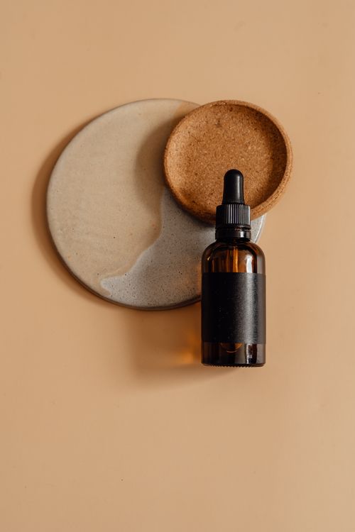 Dark glass bottle on mocha background