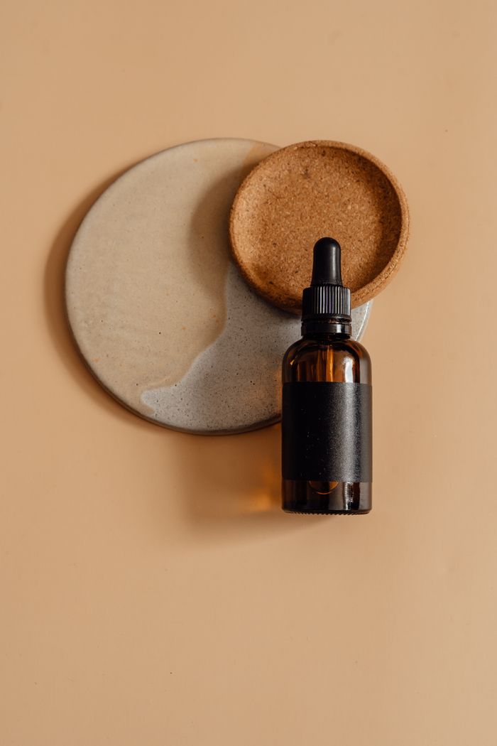 Dark glass essential oil bottle on mocha background