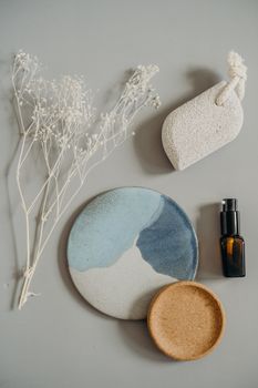 Aesthetic arrangement of beauty products and dried flowers on a neutral surface, ideal for skincare themes.