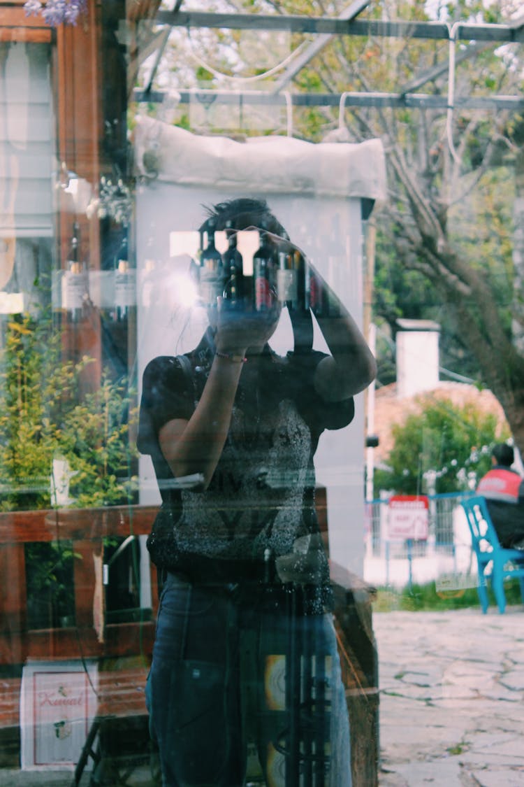 Reflection Of A Person Taking Photo Using Camera