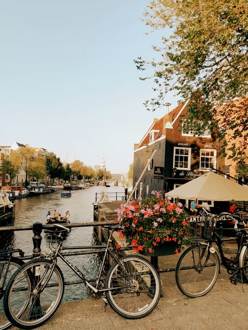 Free Charming view of Amsterdam's canal with bicycles and historic buildings in autumn. Stock Photo