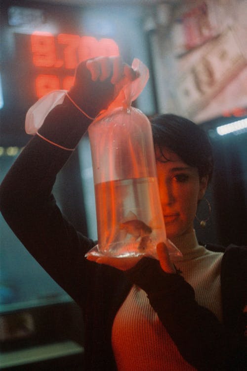 Woman showing plastic bag with fish in water