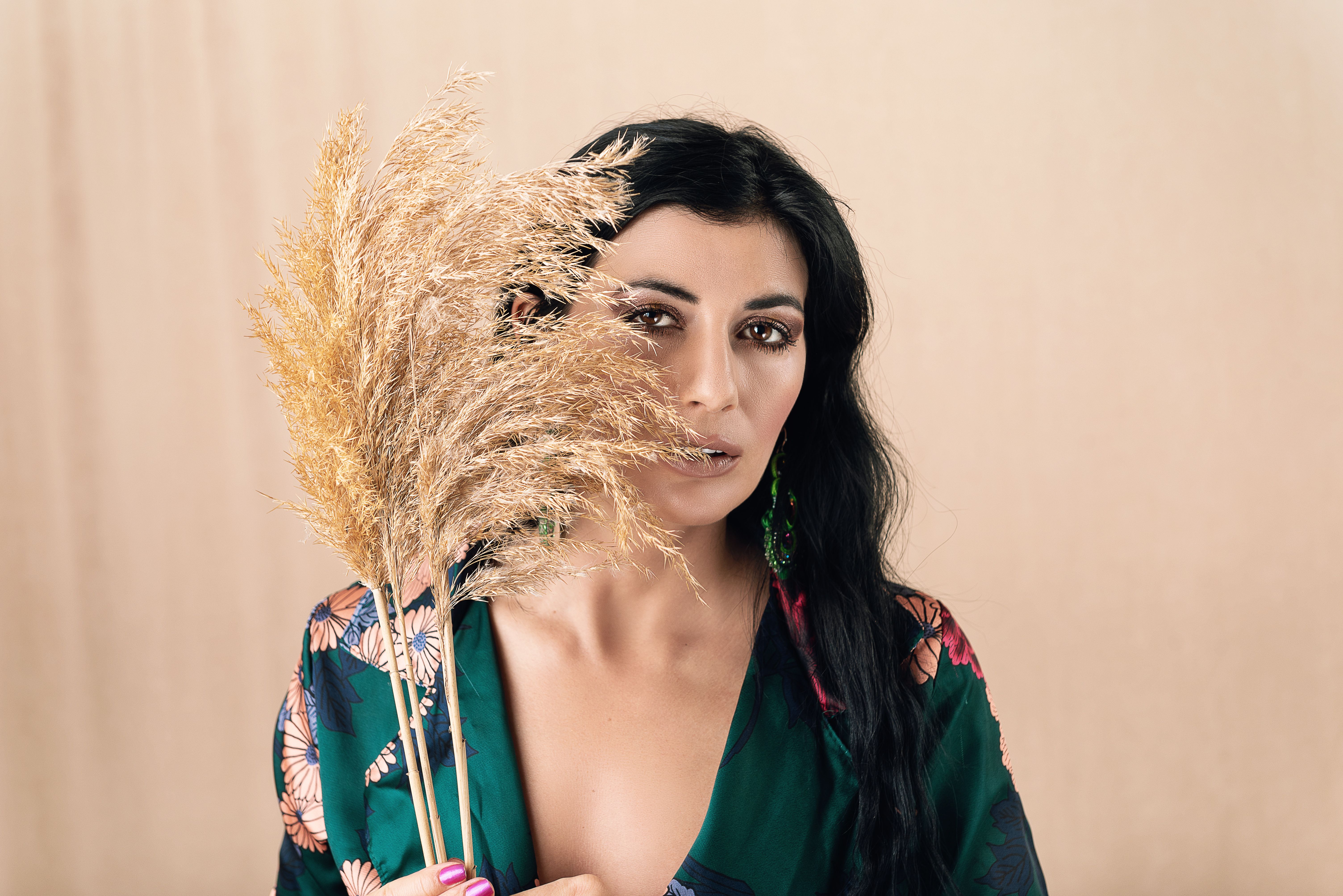 Elegant portrait of a woman holding pampas grass, highlighting natural beauty and texture.