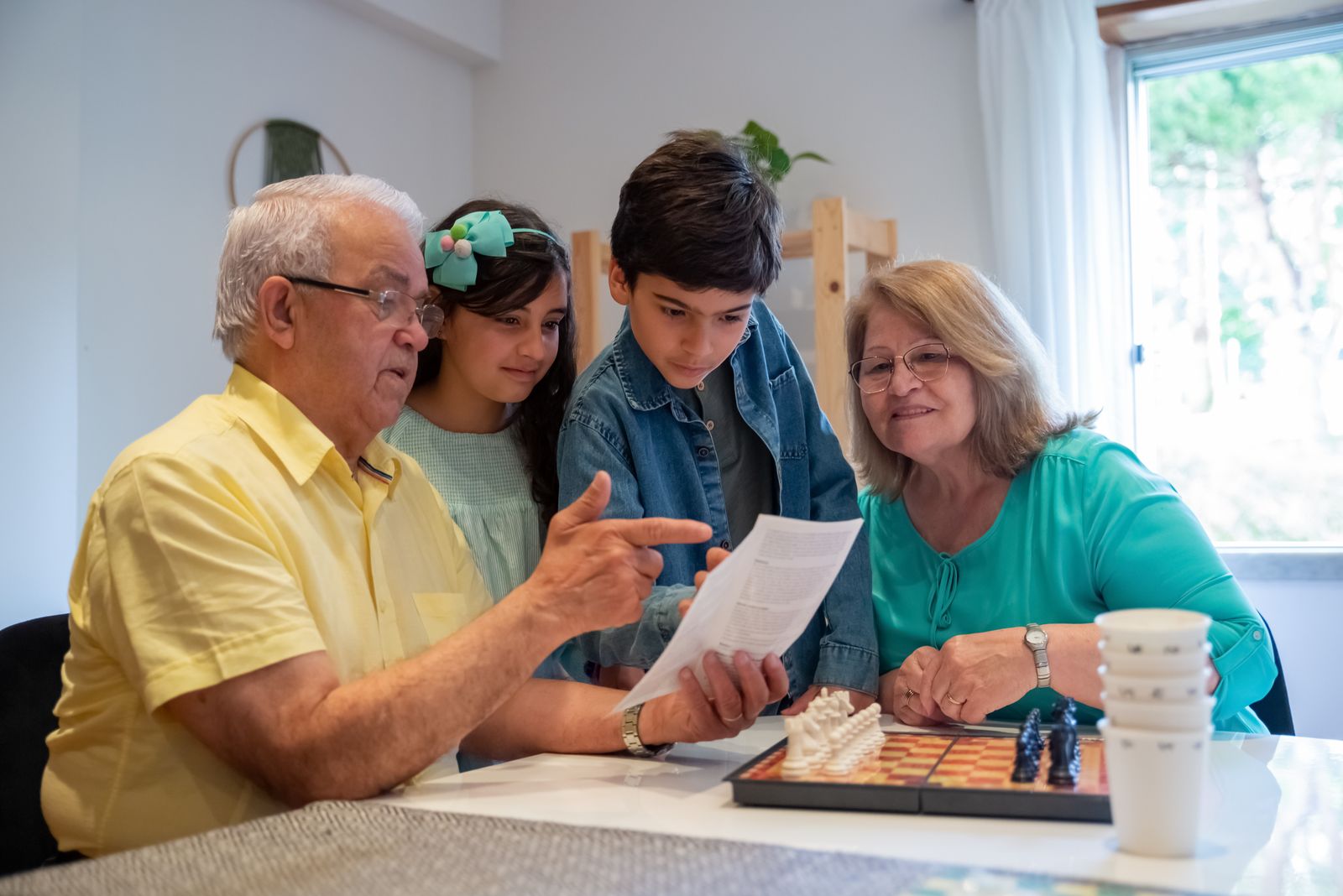A family reads through the rules and setup cards together before starting a cooperative board game at home