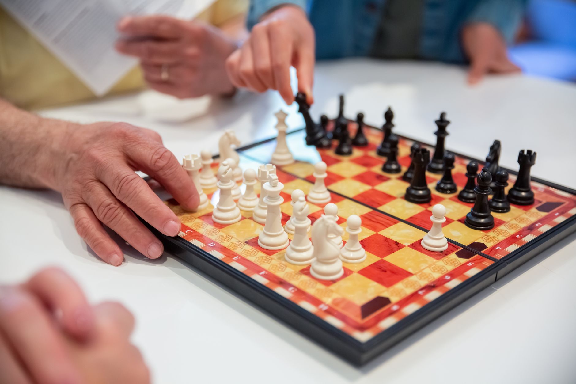 Close-up of people playing a chess game, showcasing strategic moves and focus.