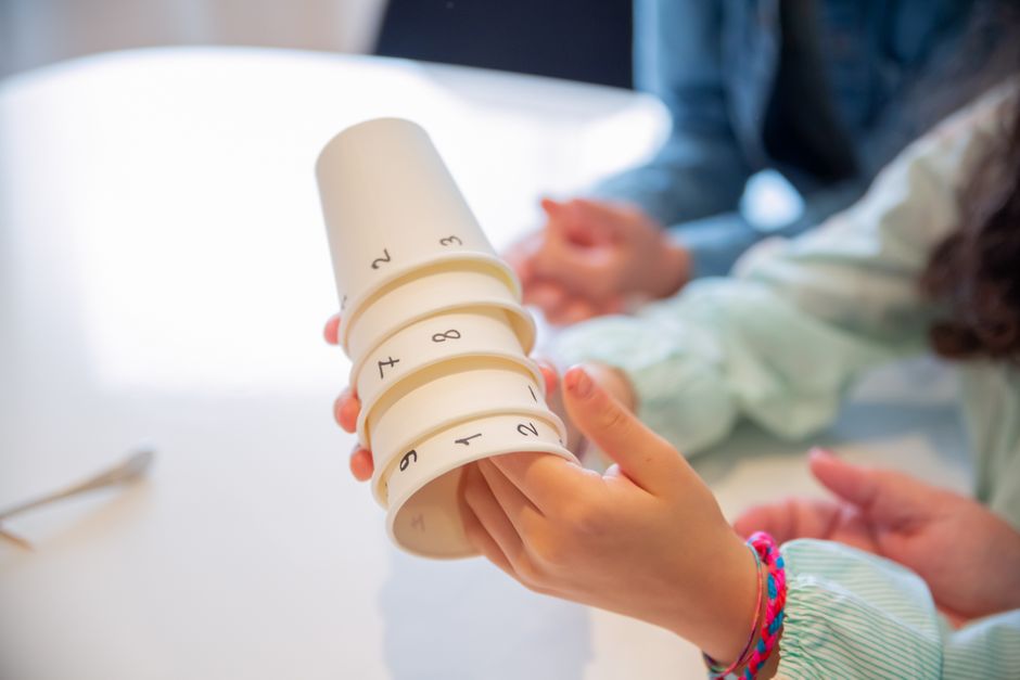 Kids playing with numbered cups for an engaging educational game, fostering teamwork and numeracy skills.