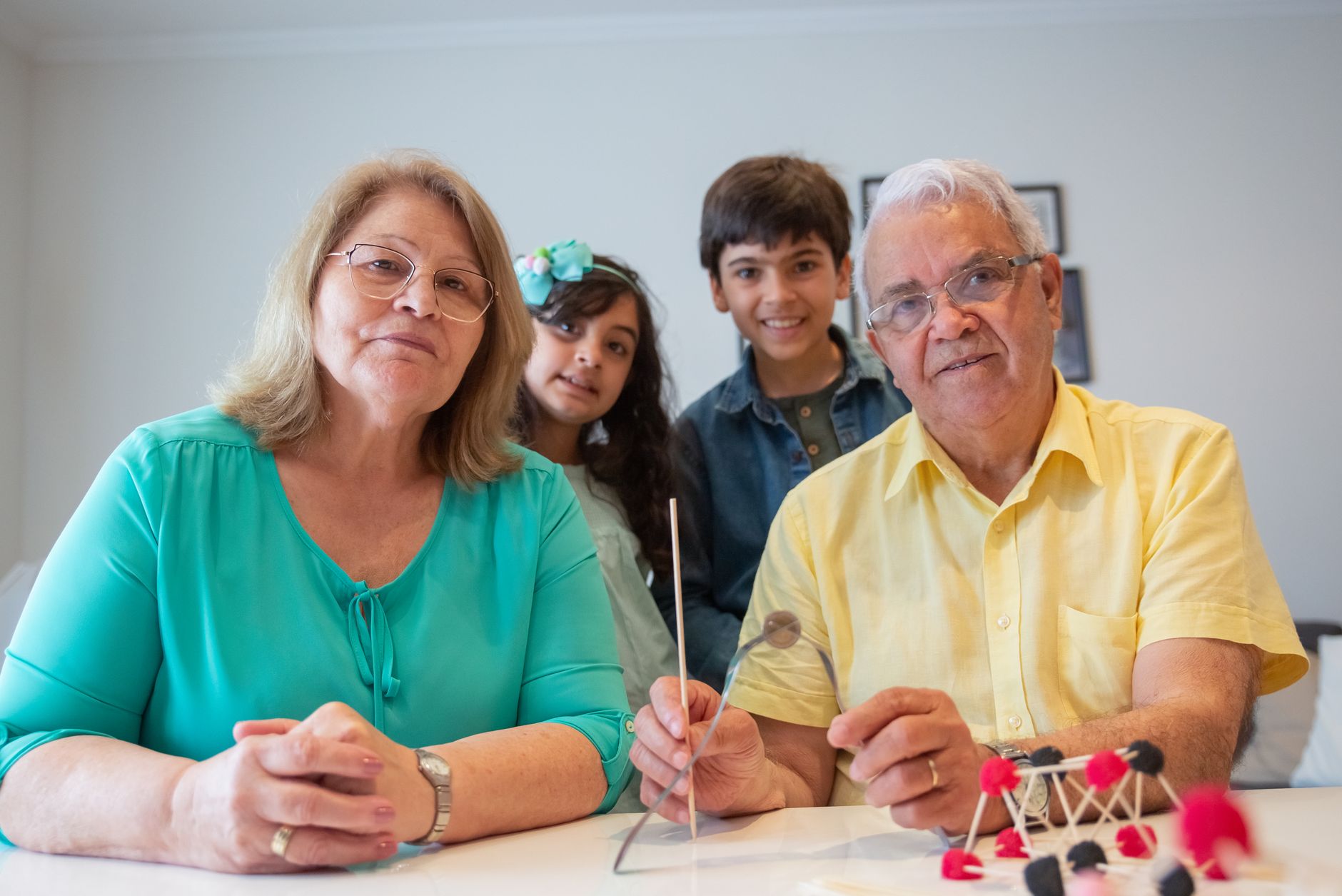 Grandparents engaging with grandchildren in an indoor activity, showcasing happy family bonding.