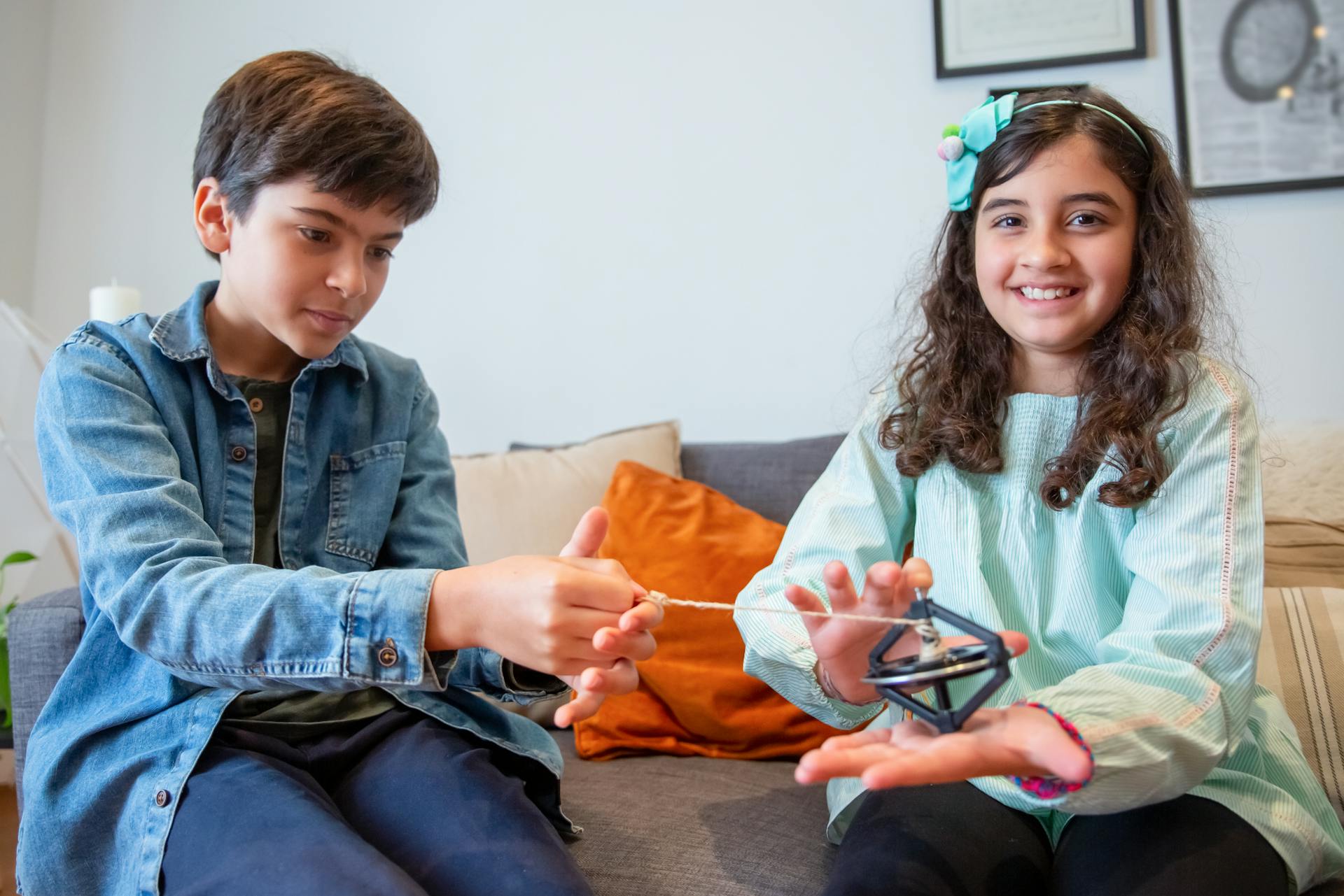 Two kids having fun with a spinning toy indoors, capturing the essence of childhood joy.