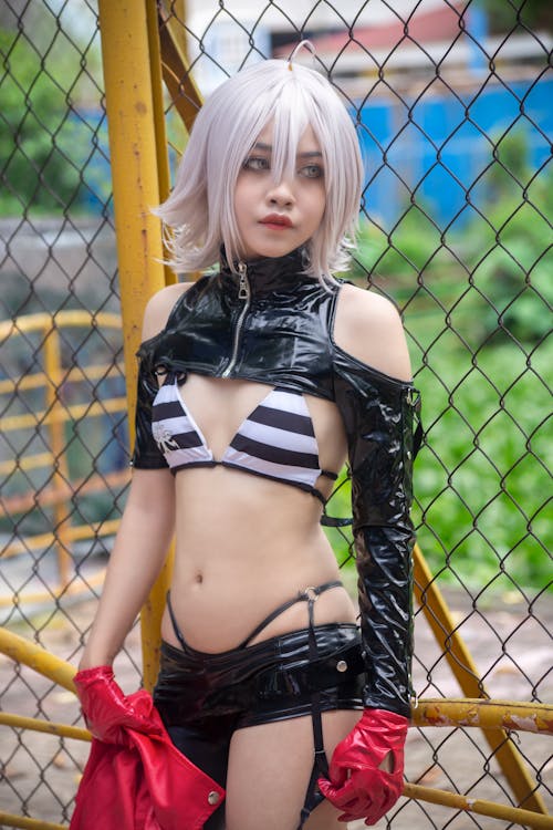 A Woman Wearing Bikini Top with Black Leather Sleeve and Bottom Standing Near the Mesh Fence