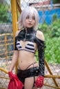 A Woman Wearing Bikini Top with Black Leather Sleeve and Bottom Standing Near the Mesh Fence