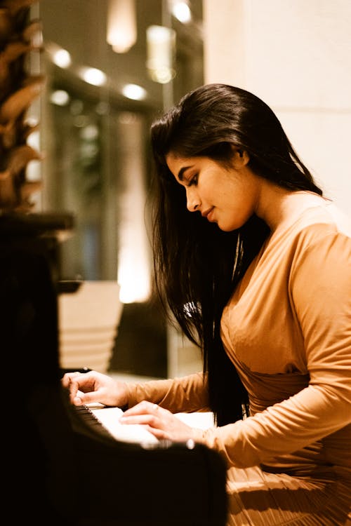 Woman in Brown Dress Playing Piano