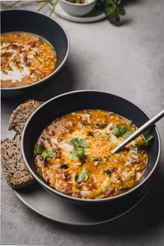 Rich and creamy tomato soup served with rustic bread on a stylish setup.