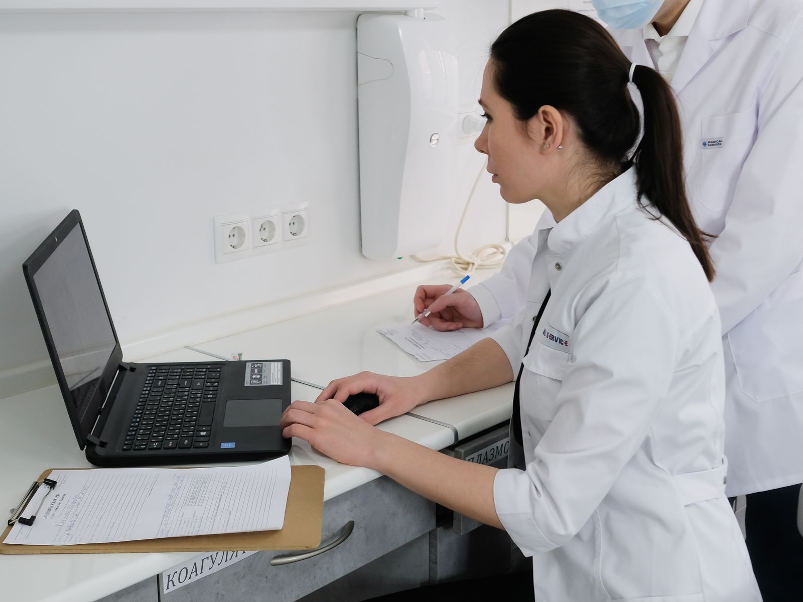 Healthcare professionals collaborating around a laptop