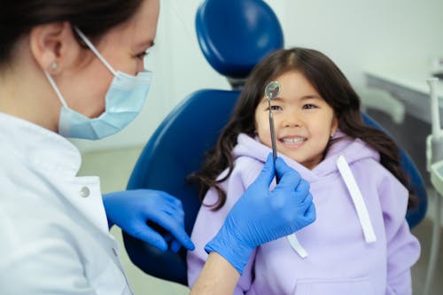 Free Dentist Showing a Dental Tool to Patient Stock Photo