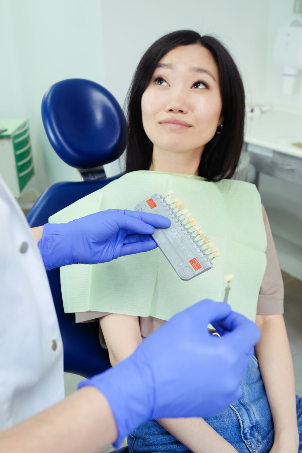 Dentist matching teeth shade for patient in Jacksonville whitening consultation