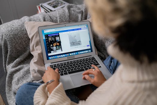 A woman uses a laptop to edit photos while sitting comfortably at home.