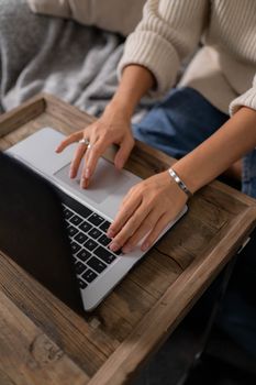 Casual setting with woman using laptop on wooden desk indoors.