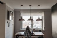 Woman Using Laptop in Front of Window