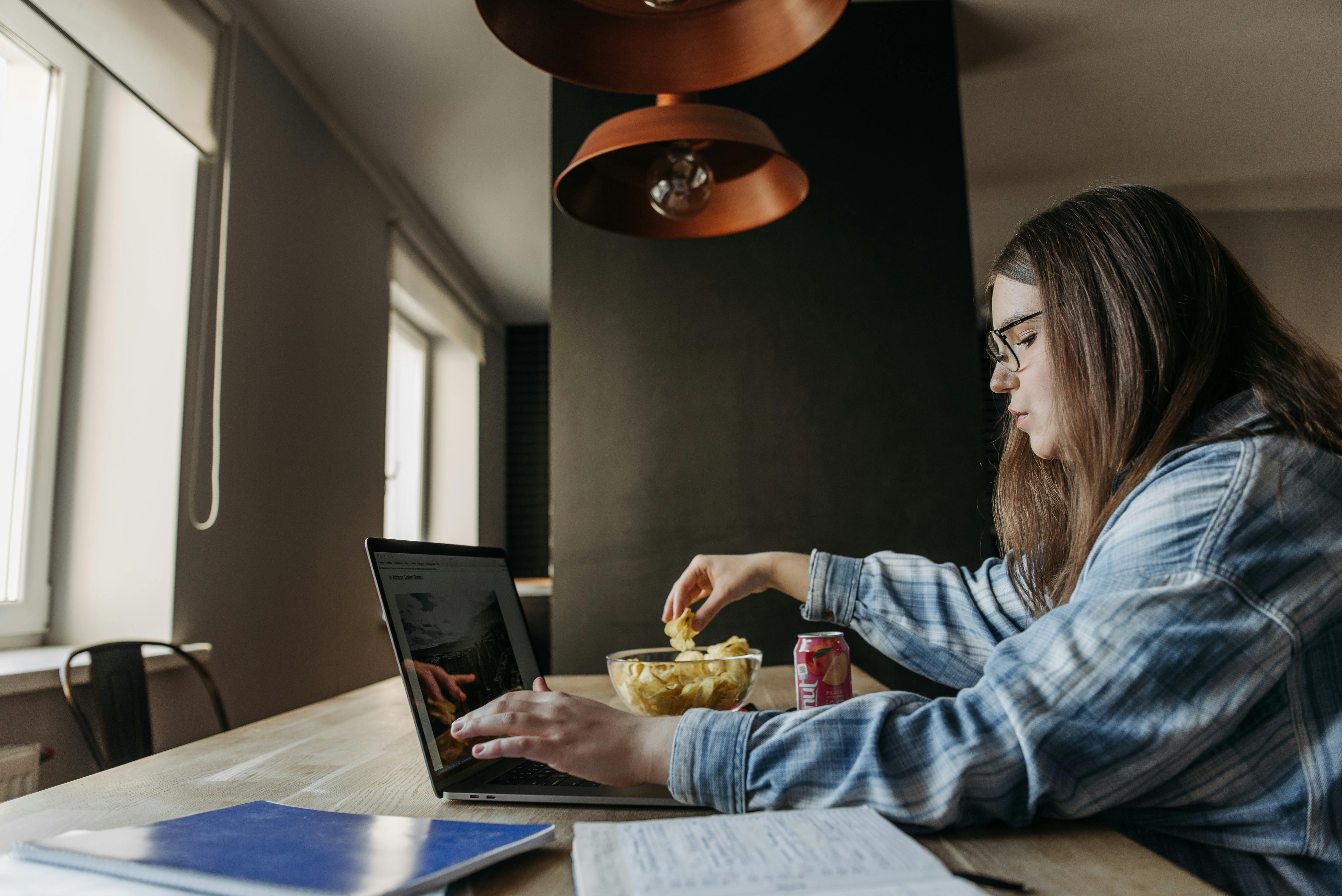 woman in blue and white plaid long sleeve shirt using laptop