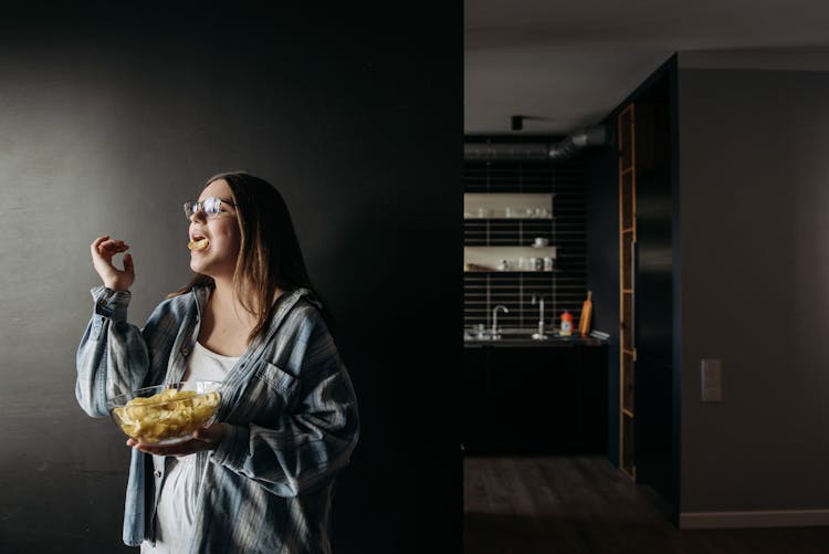 Woman In Blue And White Plaid Shirt Holding A Bowl Full Of Chips