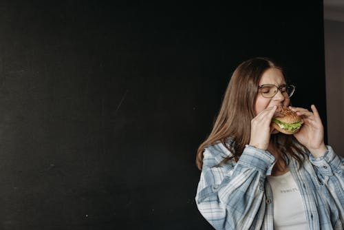 Free A Woman Eating a Hamburger  Stock Photo