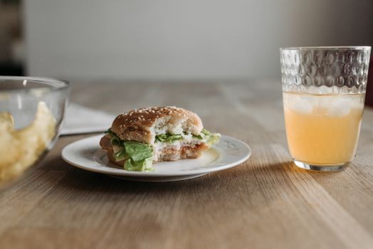 A close-up of a sandwich with juice on a wooden table, perfect for breakfast or lunch.
