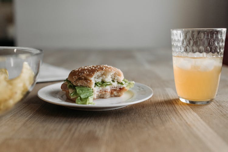 Sandwich With A Bite And Cold Drink On A Wooden Table