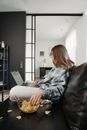 Woman in Blue and White Plaid Shirt Sitting on Black Leather Couch