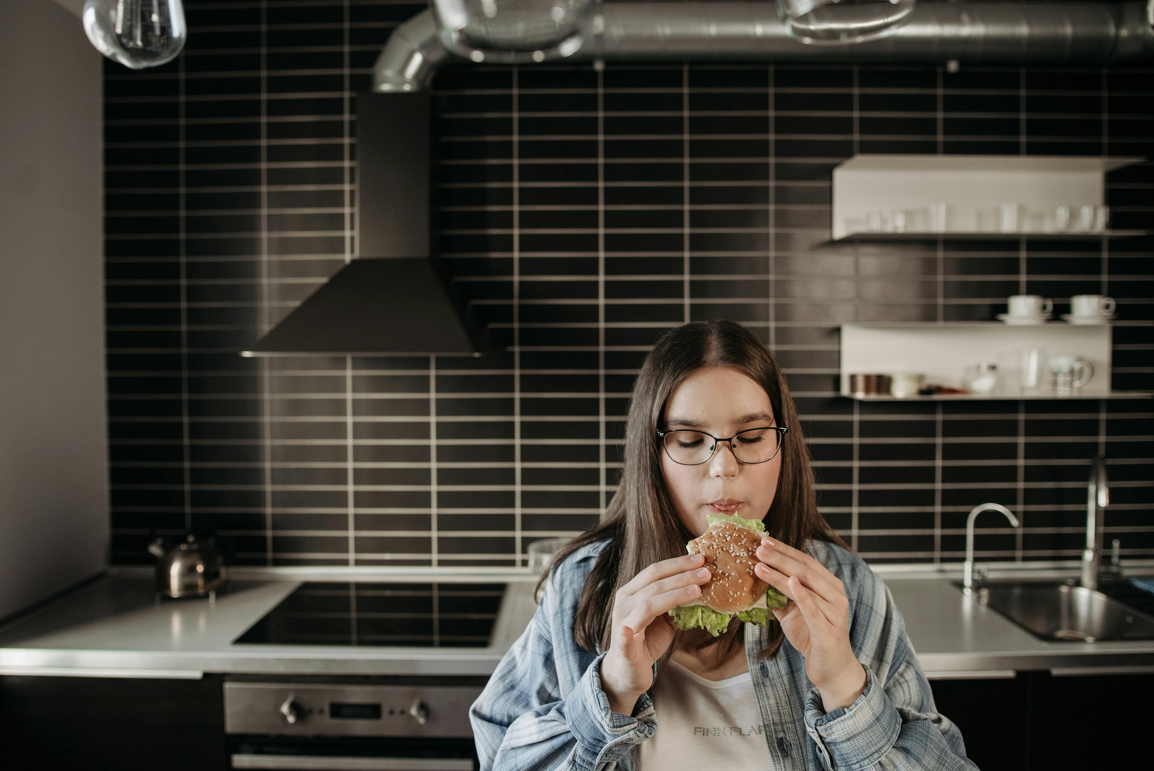 Vrouw eet rustig in haar keuken — mindful eten ondersteunt afvallen