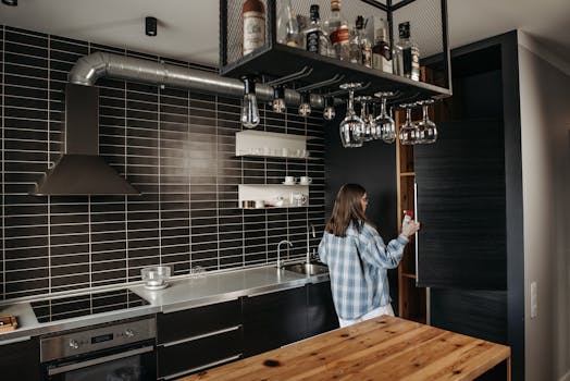 Luxurious modern kitchen with woman opening a cabinet. Ideal for contemporary design concepts.