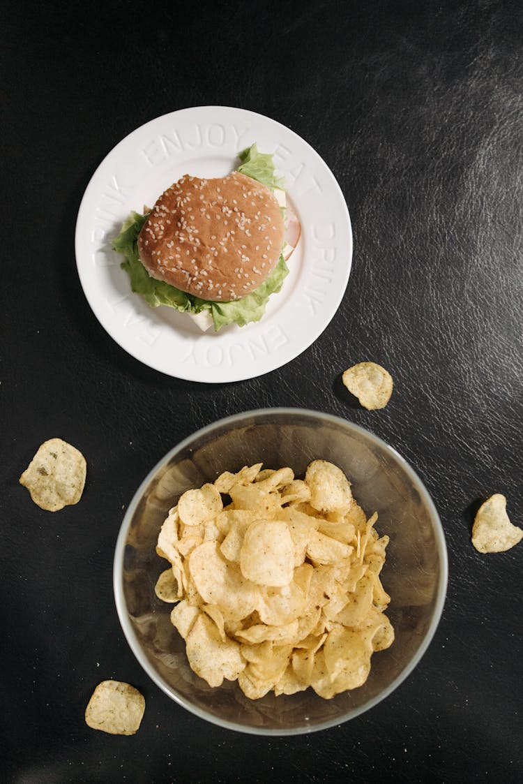 Close-Up Shot Of A Bowl Of Chips Beside A Burger