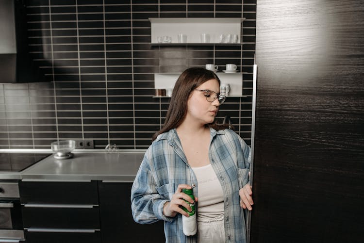 A Woman In Denim Jacket Opening A Refrigerator