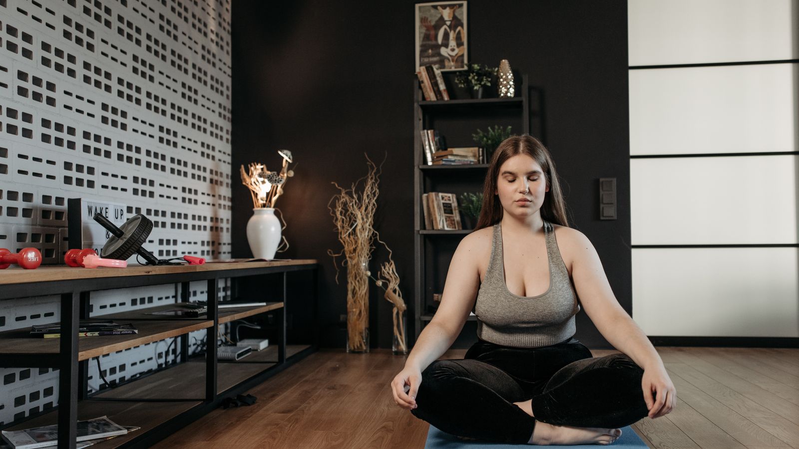A woman meditating indoors with her eyes closed