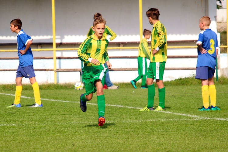 Boy Running In The Soccer Field