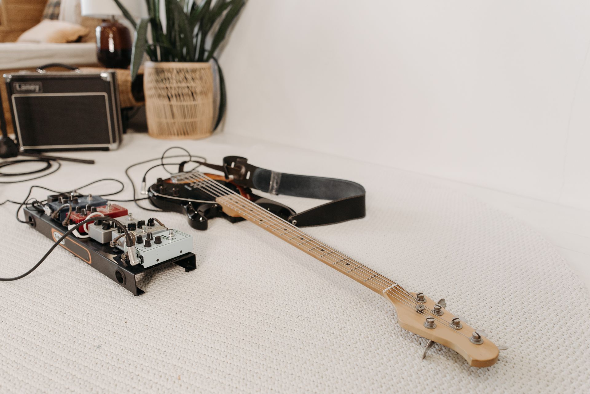 A detailed view of an electric guitar and amplifier setup in a cozy, indoor setting.