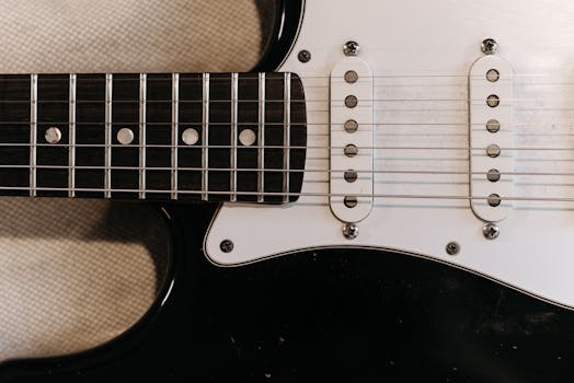 Detailed view of electric guitar showcasing strings and pickguard, ideal for music themes.