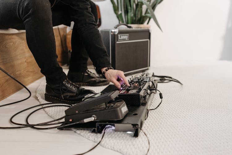 A Person Setting Up The Pedal Board