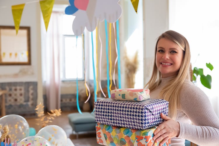 Women Holding A Stack Of Gifts