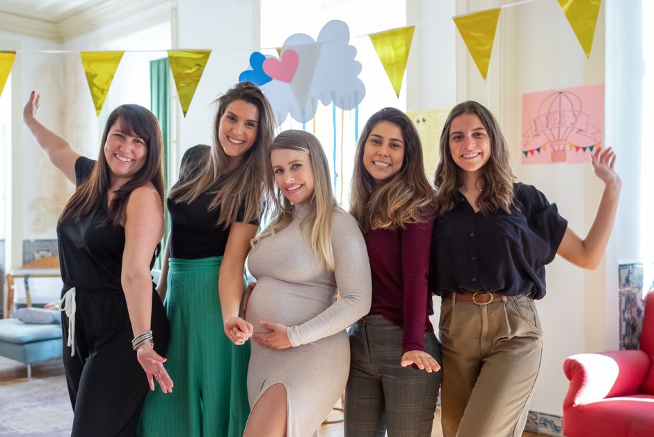 Como Cultivar a Criatividade na Maternidade e na Educação dos Filhos 2 A group of women celebrating a baby shower with decorations and smiles indoors.