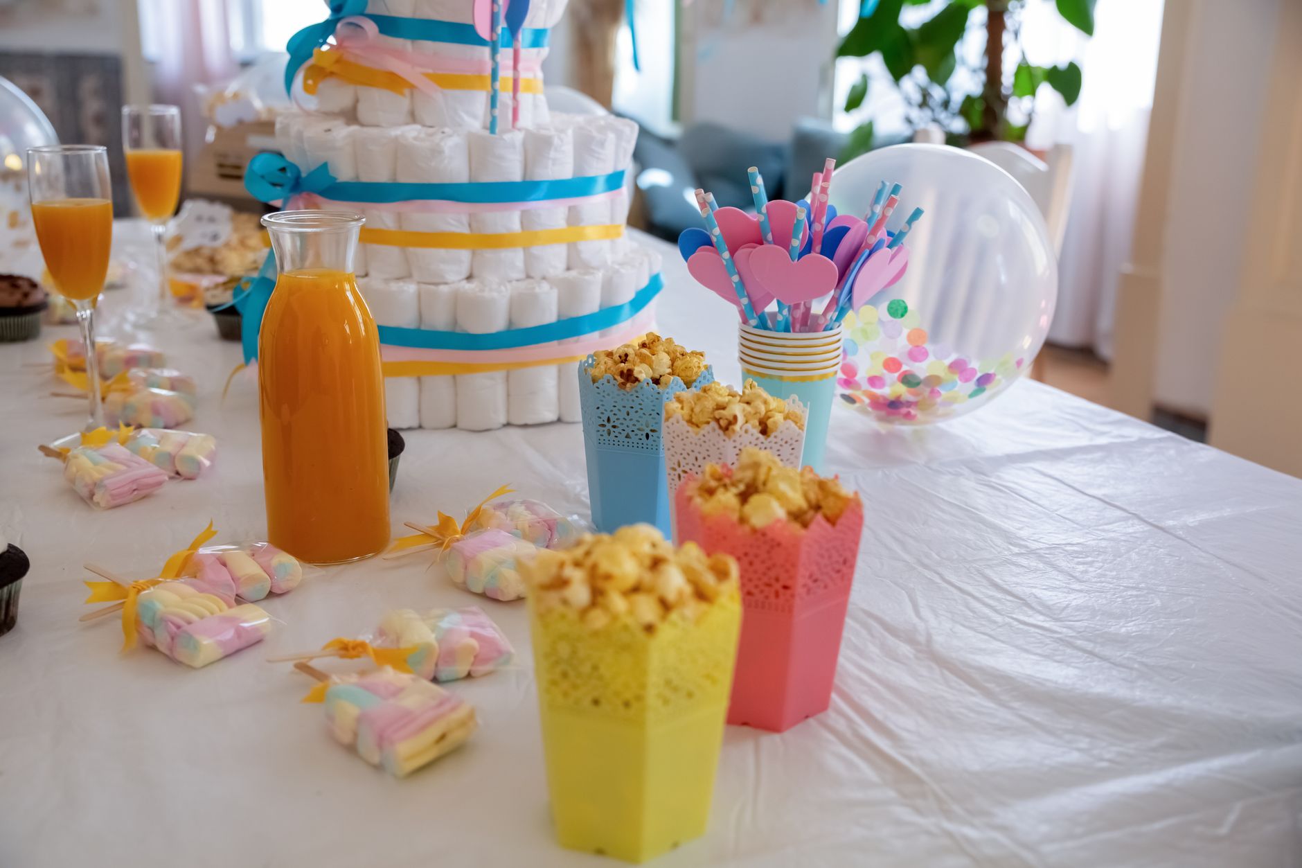 A vibrant setup for a baby shower featuring popcorn, snacks, and colorful decor.